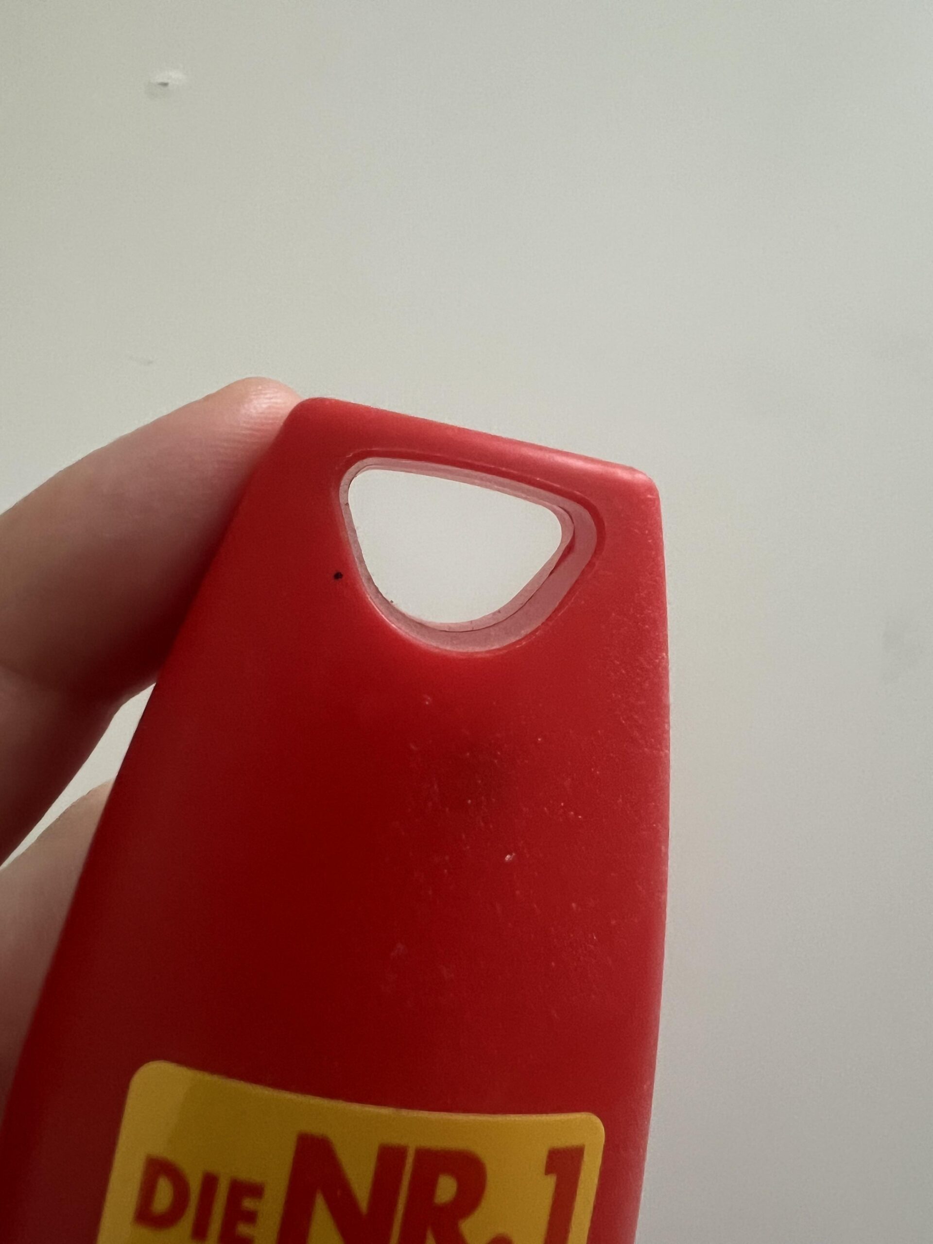 Close-up of the triangular hanging opening moulded into the red Autan Tropical cap