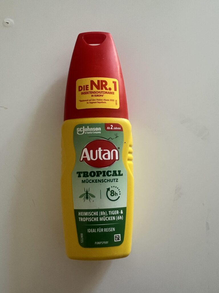 Original photograph of my Autan Tropical Pumpspray 100 ml bottle, with red cap and green 8h/6h mosquito protection front label