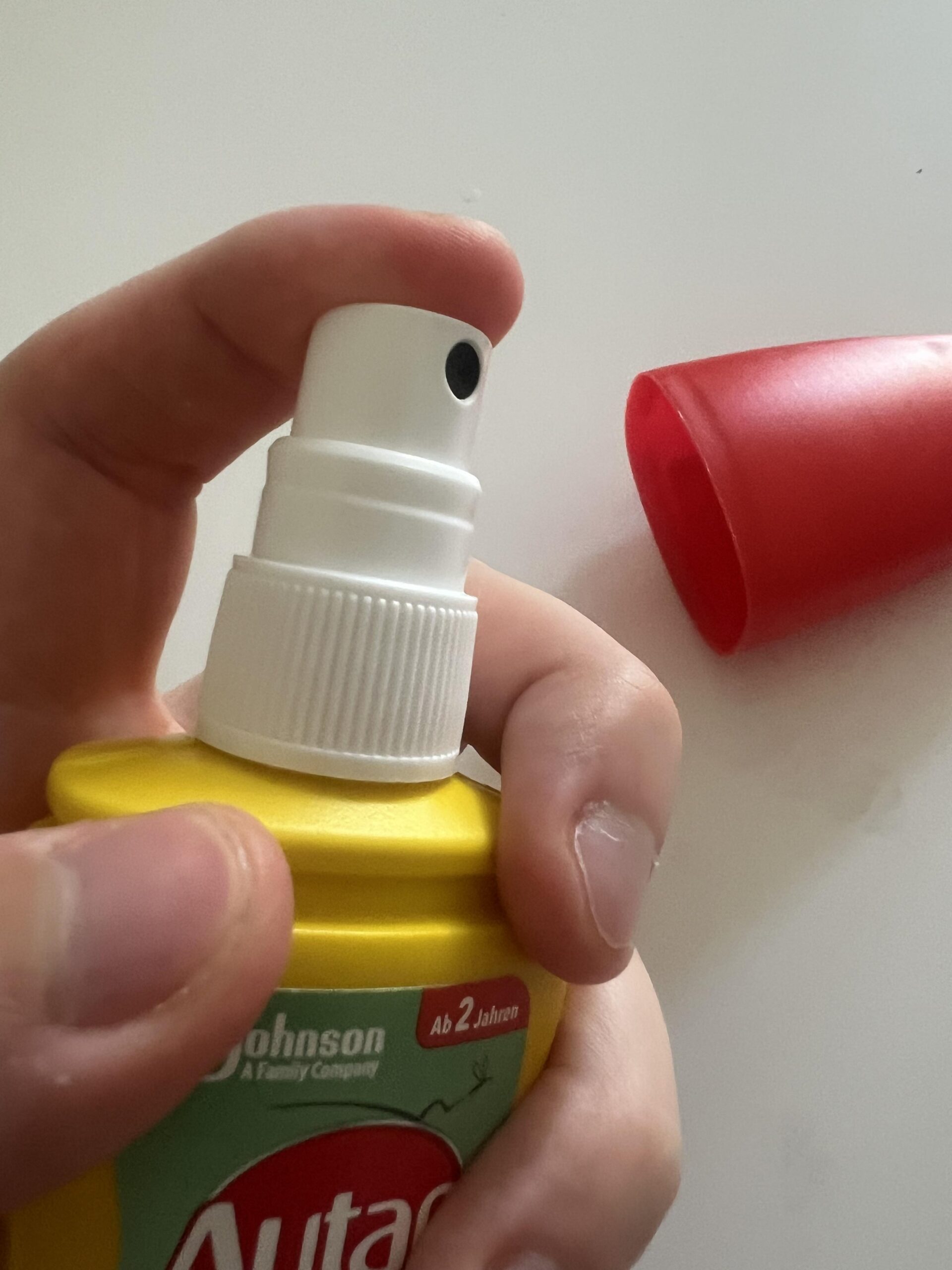 Close-up of the white spray nozzle on my Autan Tropical bottle with the red cap removed