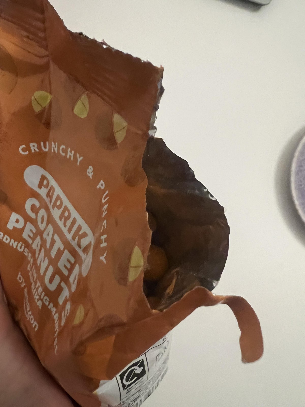 Original photograph of an opened orange bag of by Amazon paprika-coated peanuts