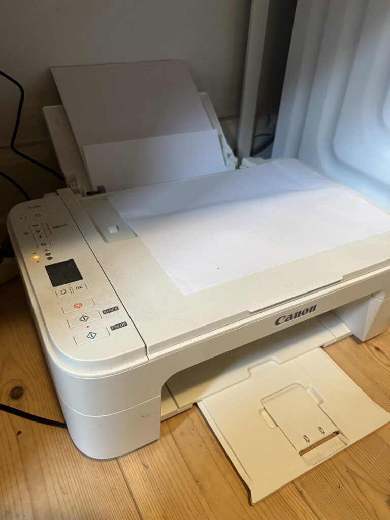 Original three-quarter photo of my white Canon PIXMA TS3351 printer with rear paper feeder and front output tray visible