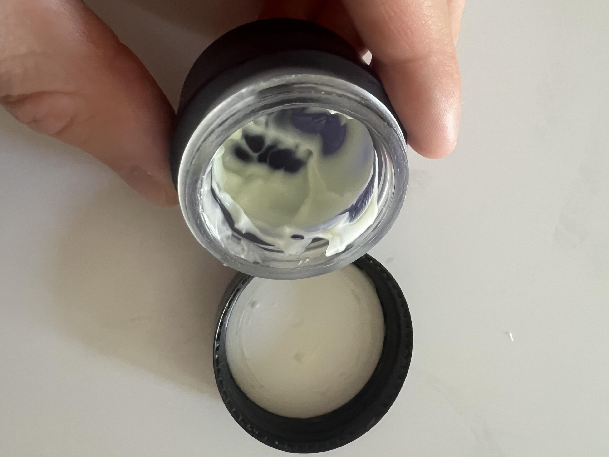 Original photograph of open Eight Saints Smooth Sailing eye cream jar with visible cream residue inside