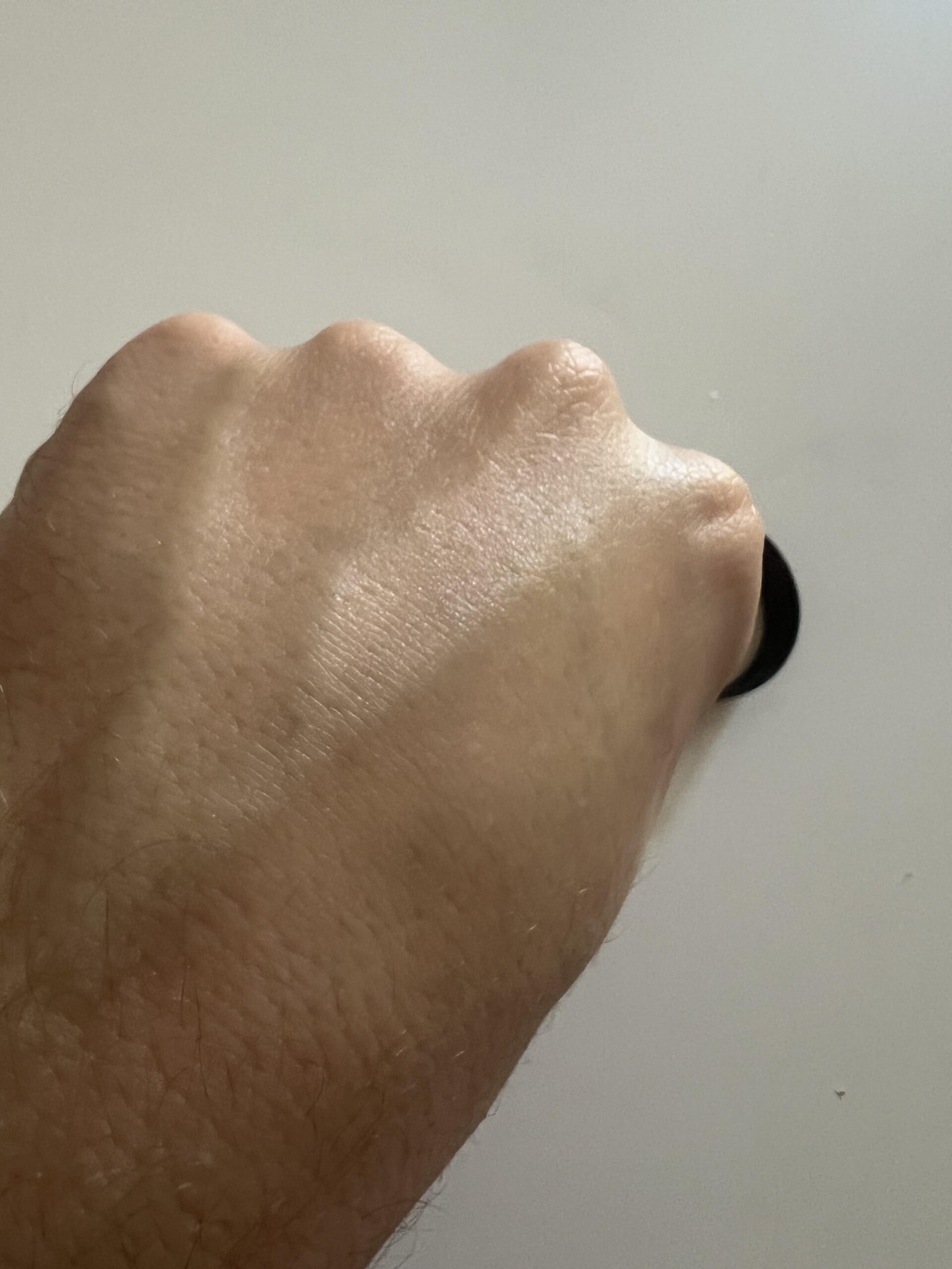 Back of the hand showing the Eight Saints eye cream spread over skin