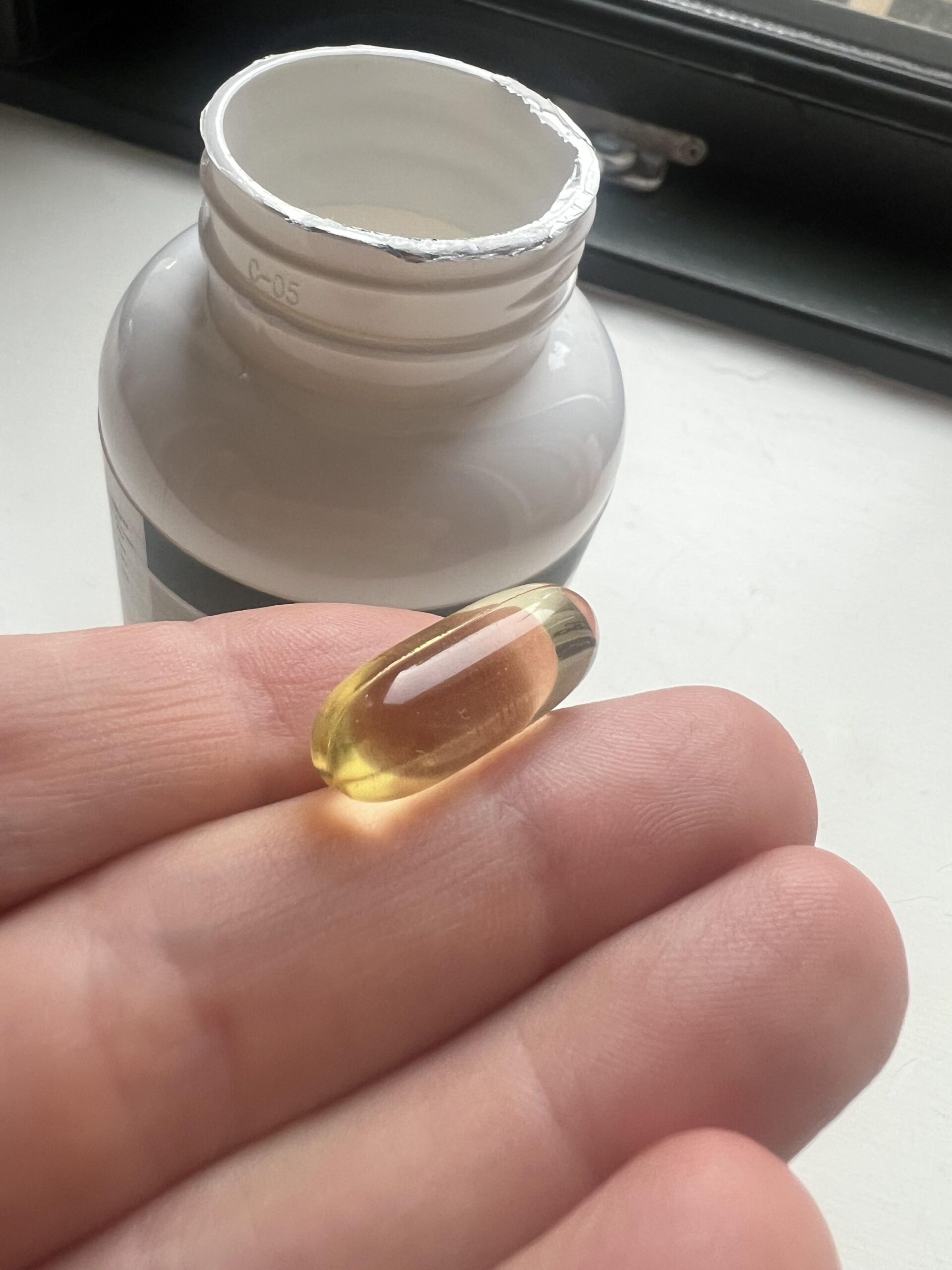 Close-up photograph of an EXVital golden algae oil capsule