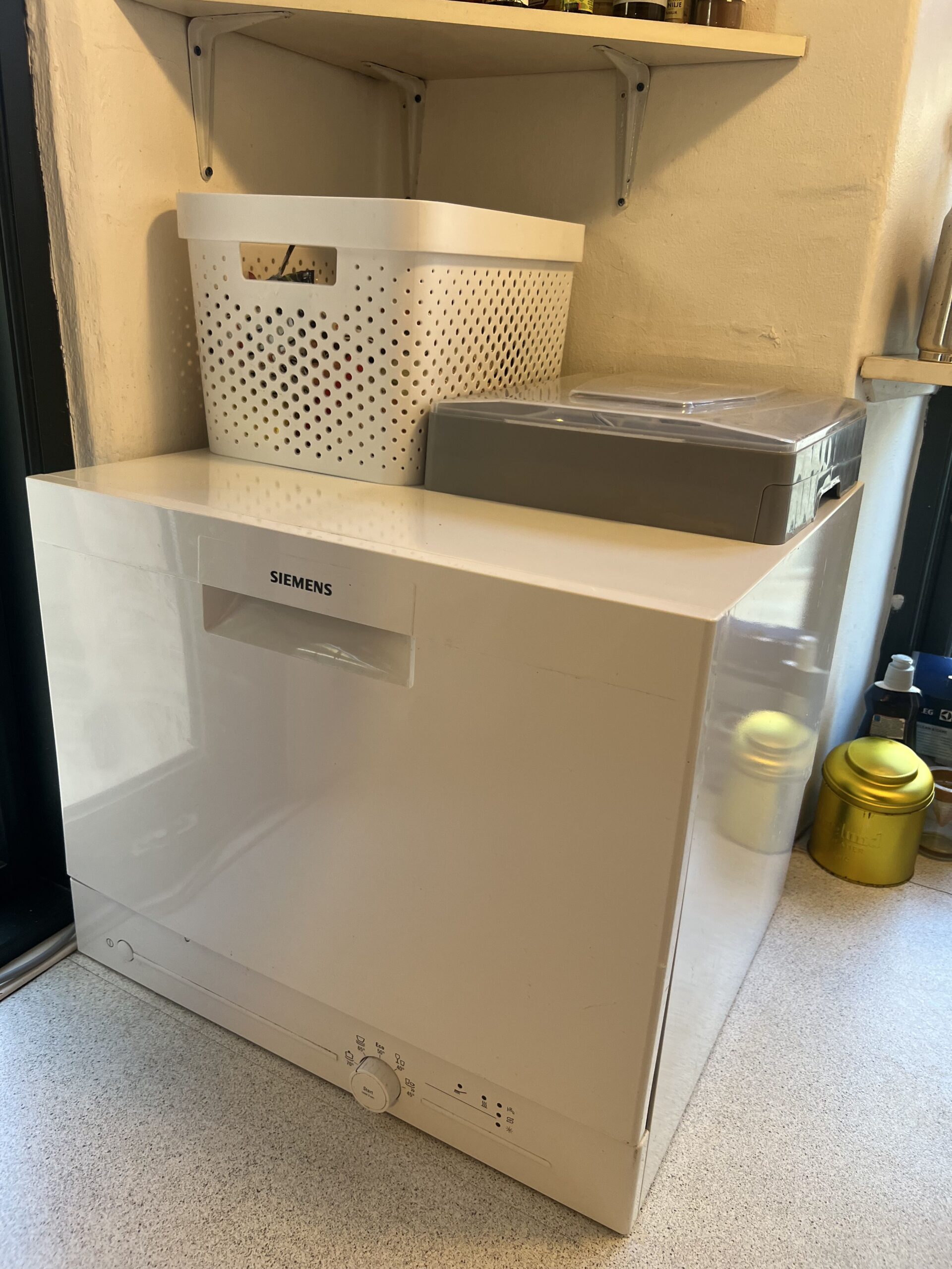 Siemens countertop dishwasher used for storage on top in a small kitchen