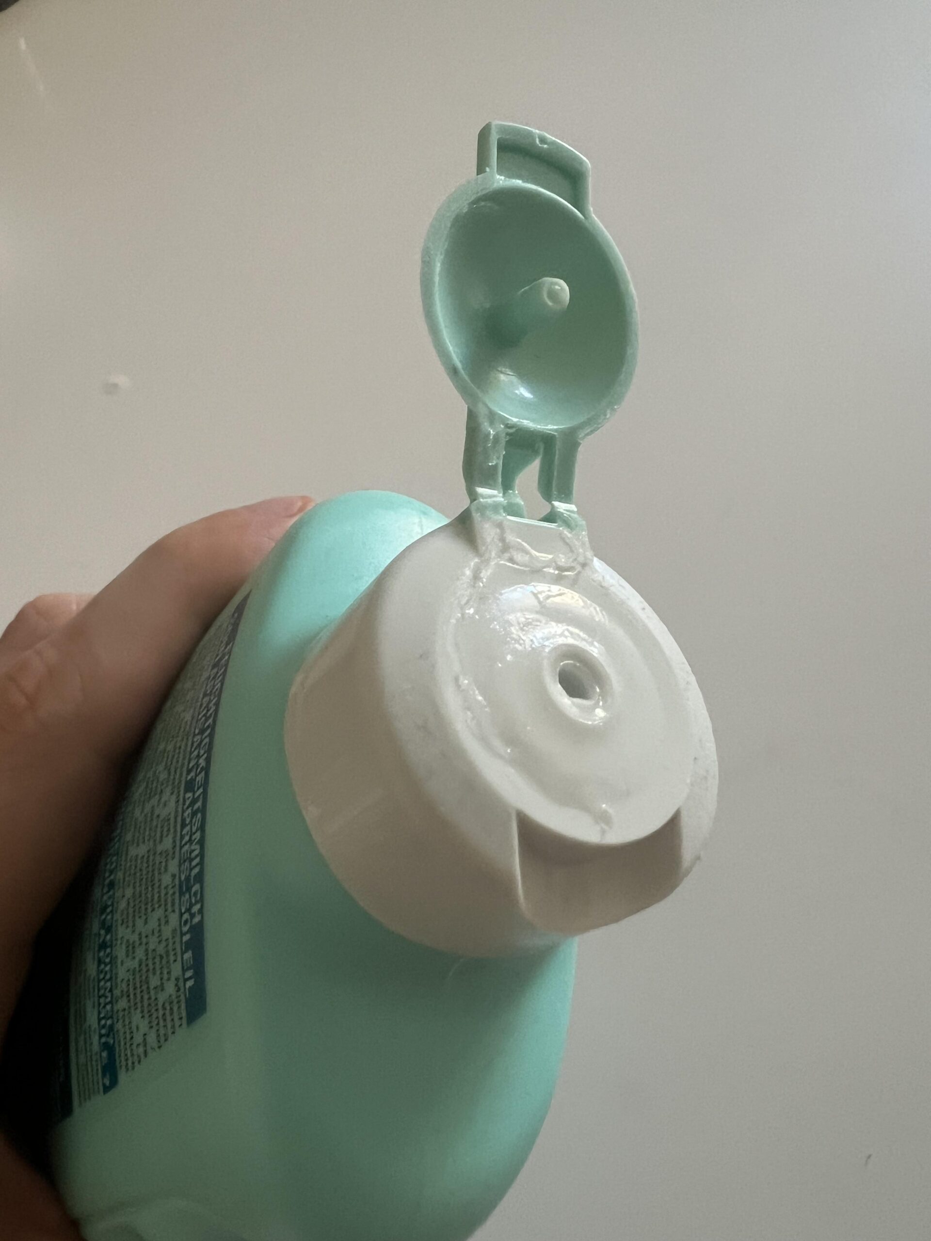 Original close-up photograph of Garnier After Sun 400ml bottle with hinged cap flipped open and dispensing hole visible