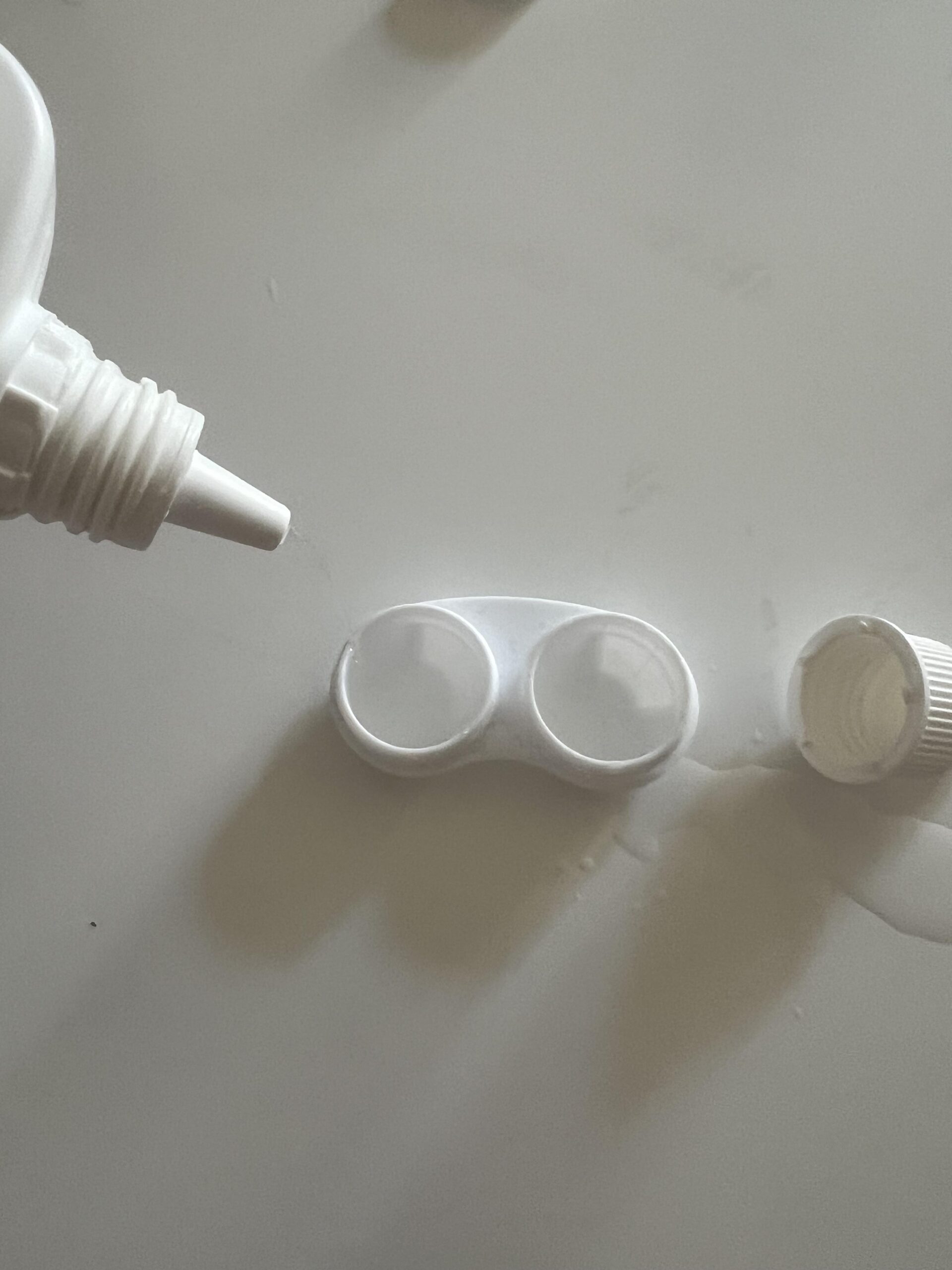 Healthcare by Amazon contact lens solution nozzle positioned over the two wells of an open contact lens case