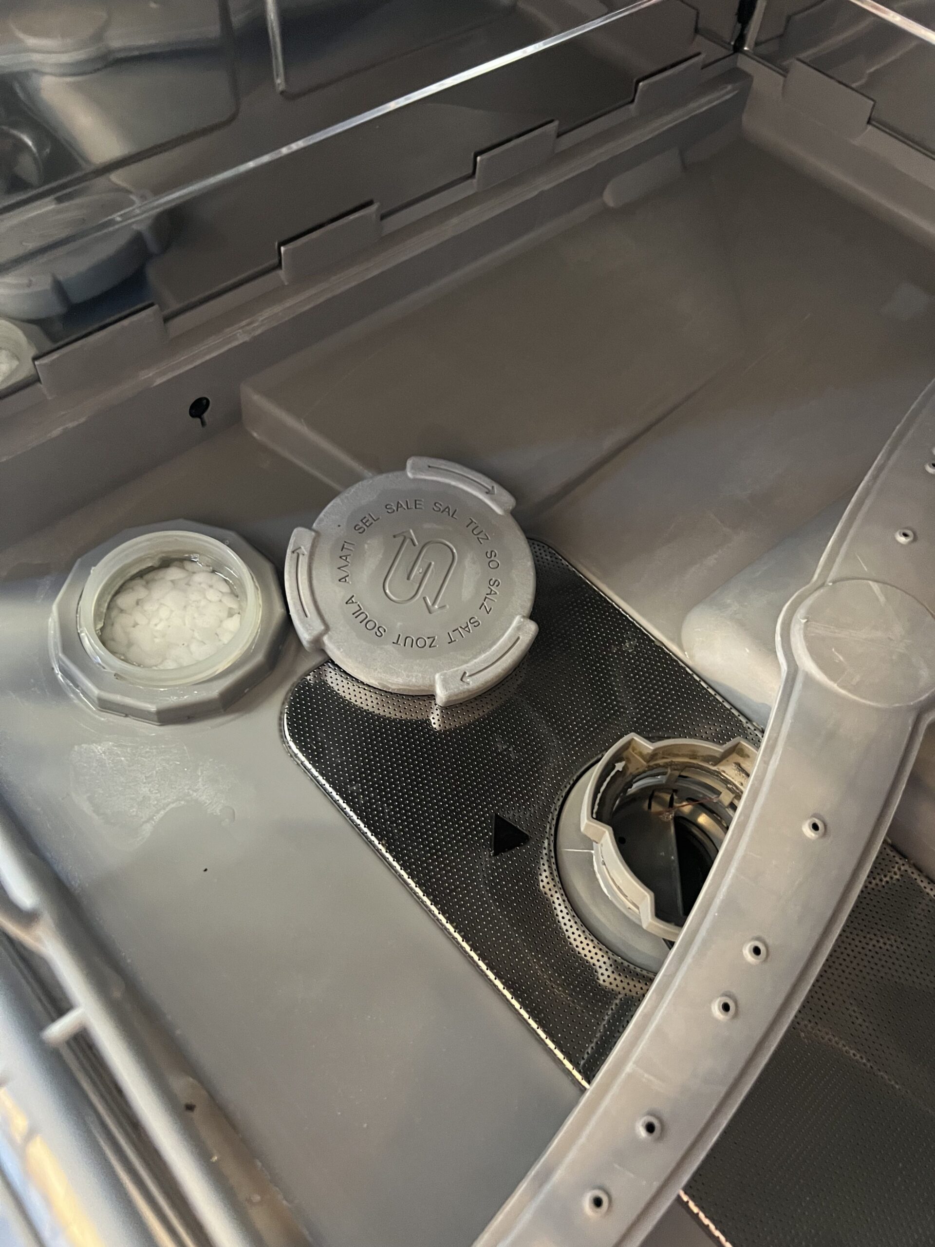 Inside of Siemens countertop dishwasher showing spray arm and salt compartment