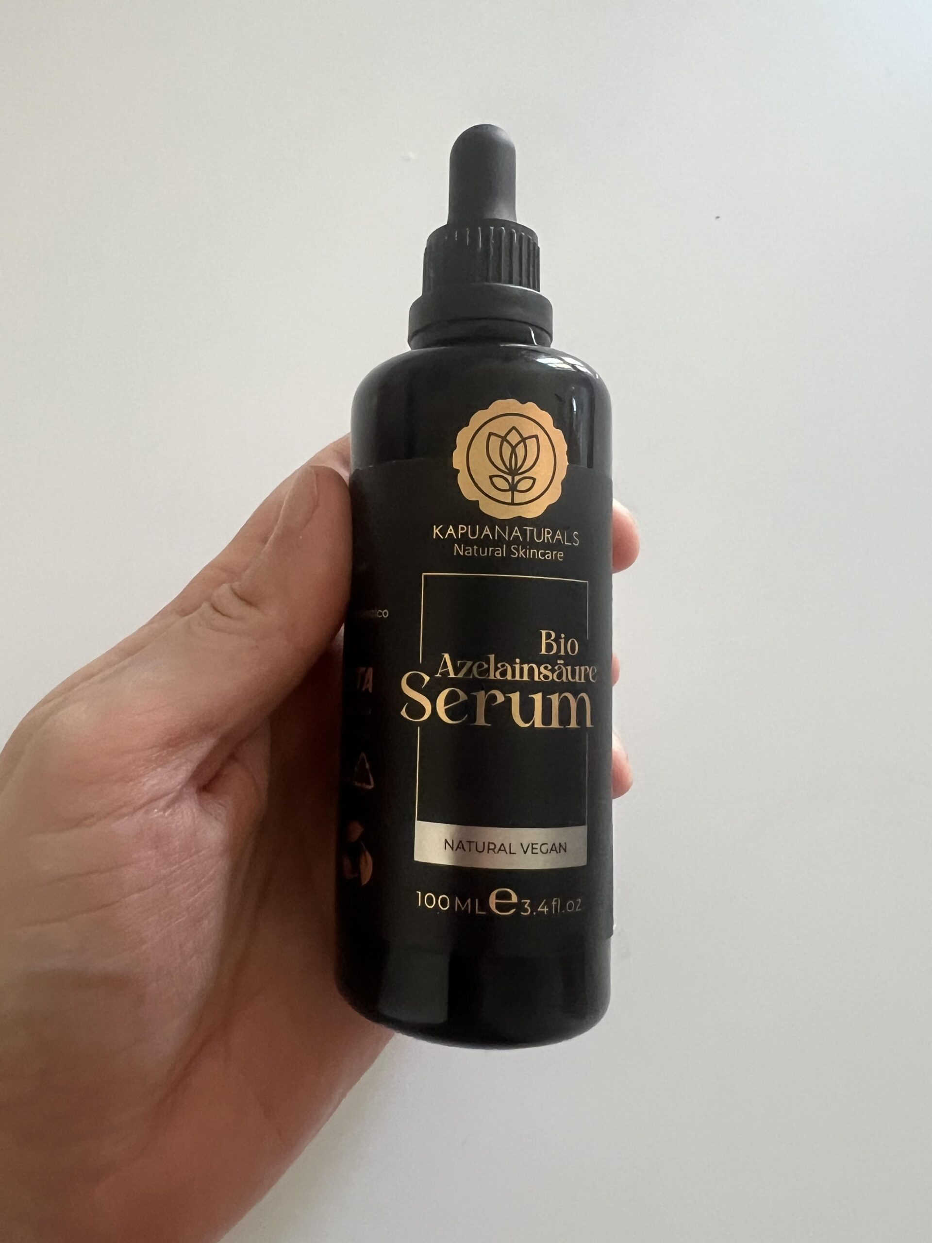 My original upright photograph of Kapua Naturals Bio Azelainsäure Serum 100 ml black dropper bottle with gold logo and label