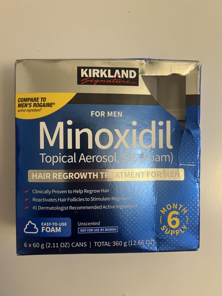 Original photo of a blue Kirkland Signature Minoxidil Topical Aerosol 5% Foam for Men box, 6 cans of 60 g, six-month supply