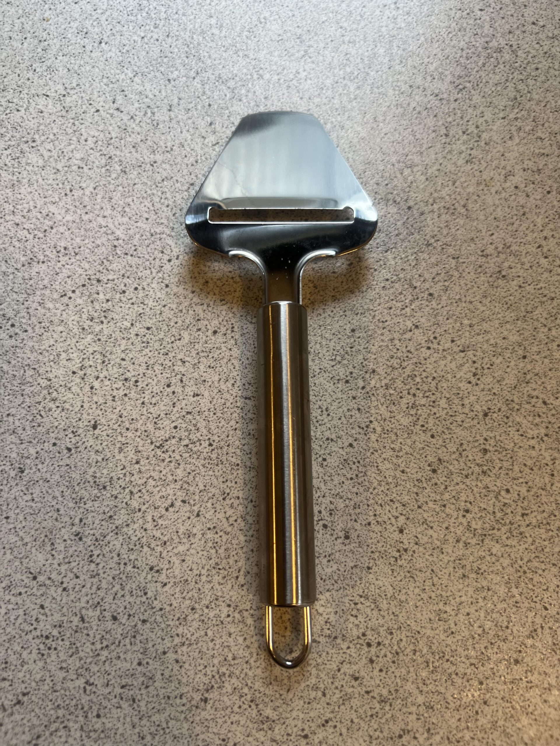 LAMXD stainless-steel cheese slicer viewed from the cutting head side on a speckled countertop