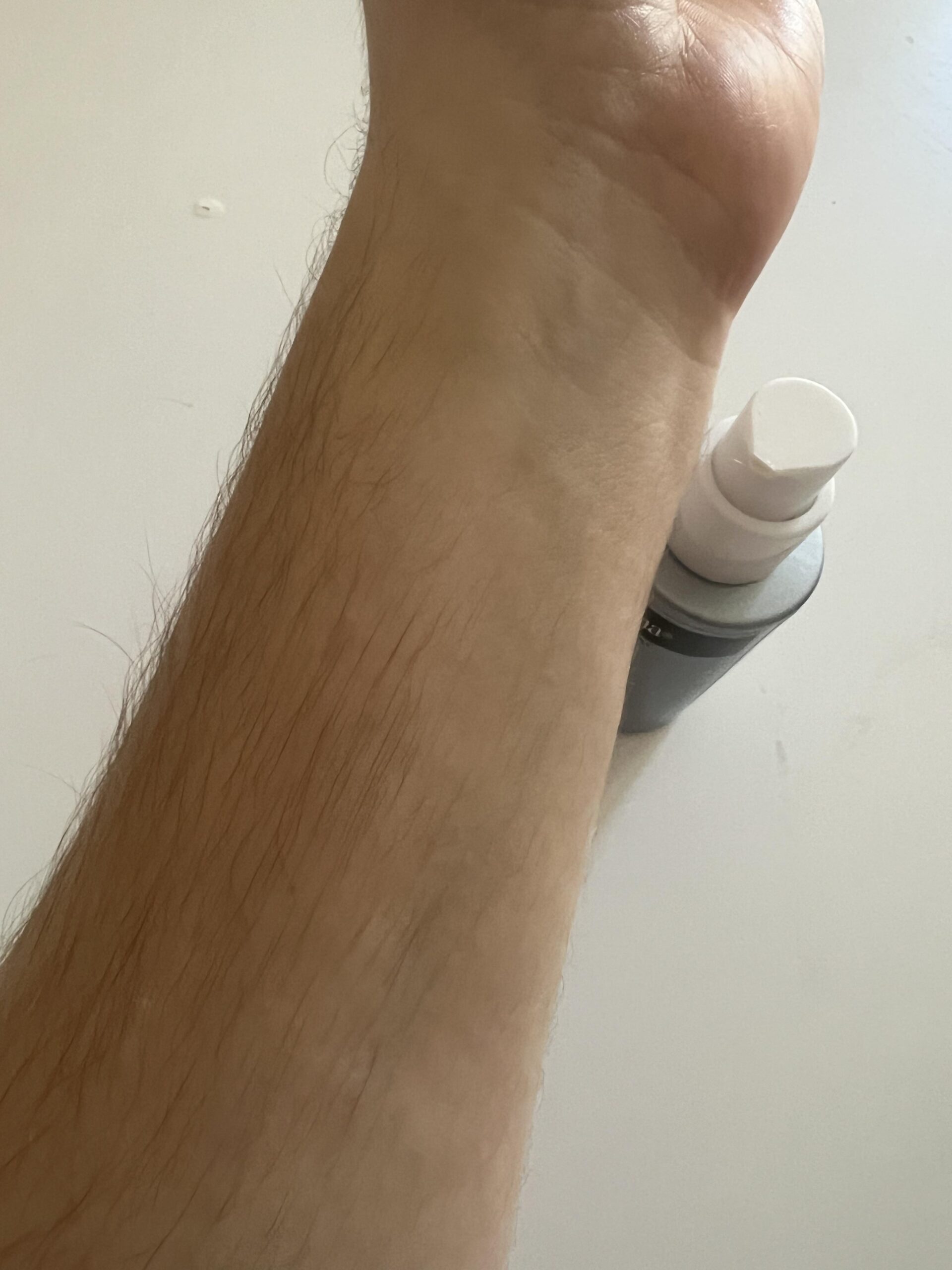 My forearm after spreading Neutrogena Retinol Boost night cream, with its actual bottle