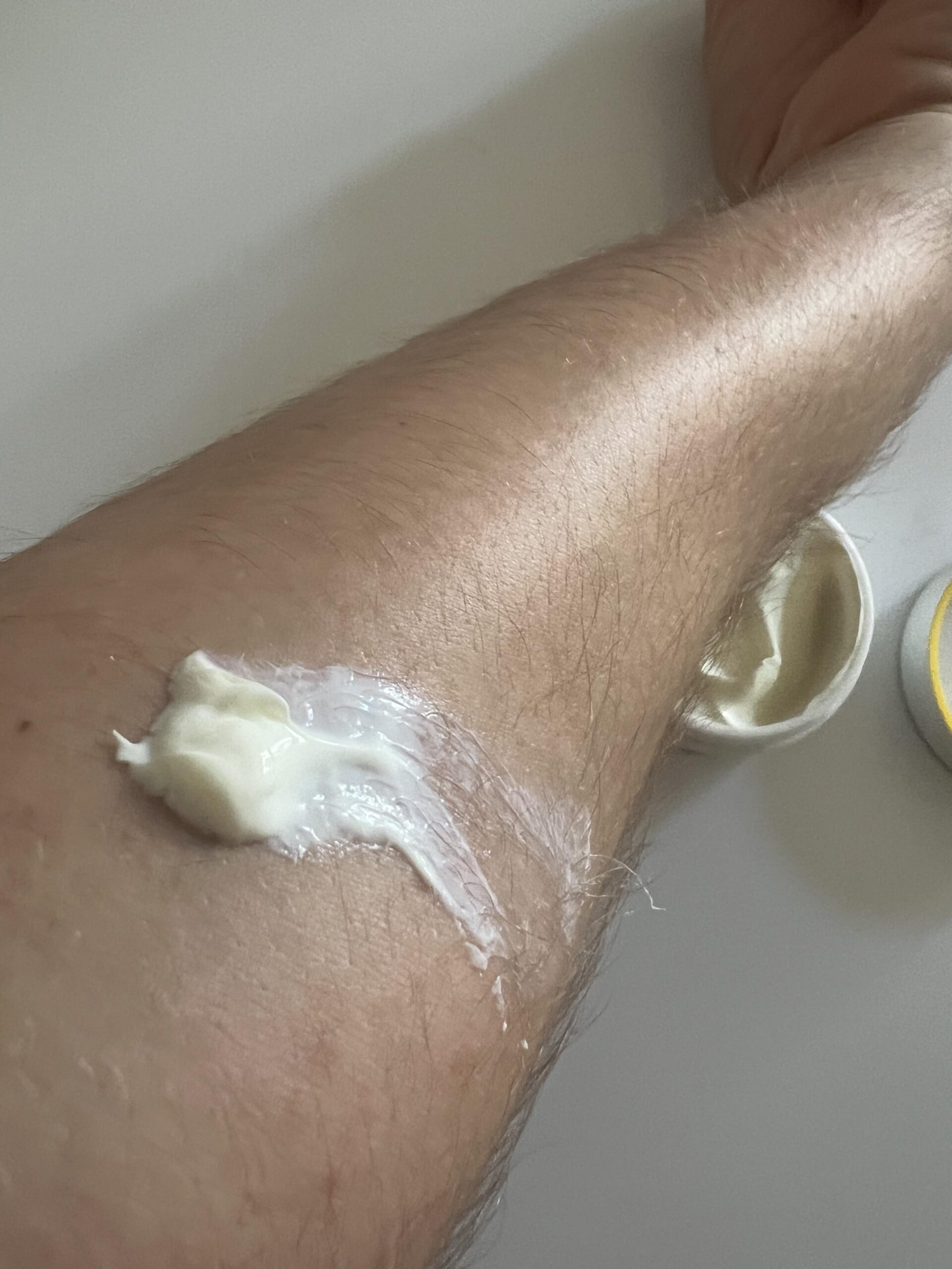 White strip of NIVEA Q10 SPF 30 moisturiser on forearm before spreading
