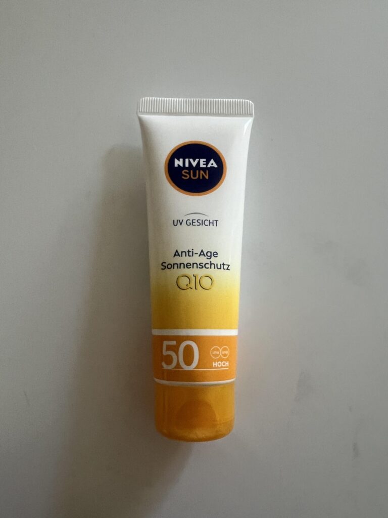 Original upright photograph of the white and yellow NIVEA SUN UV Gesicht Anti-Age Sonnenschutz Q10 SPF 50 50 ml tube with orange cap