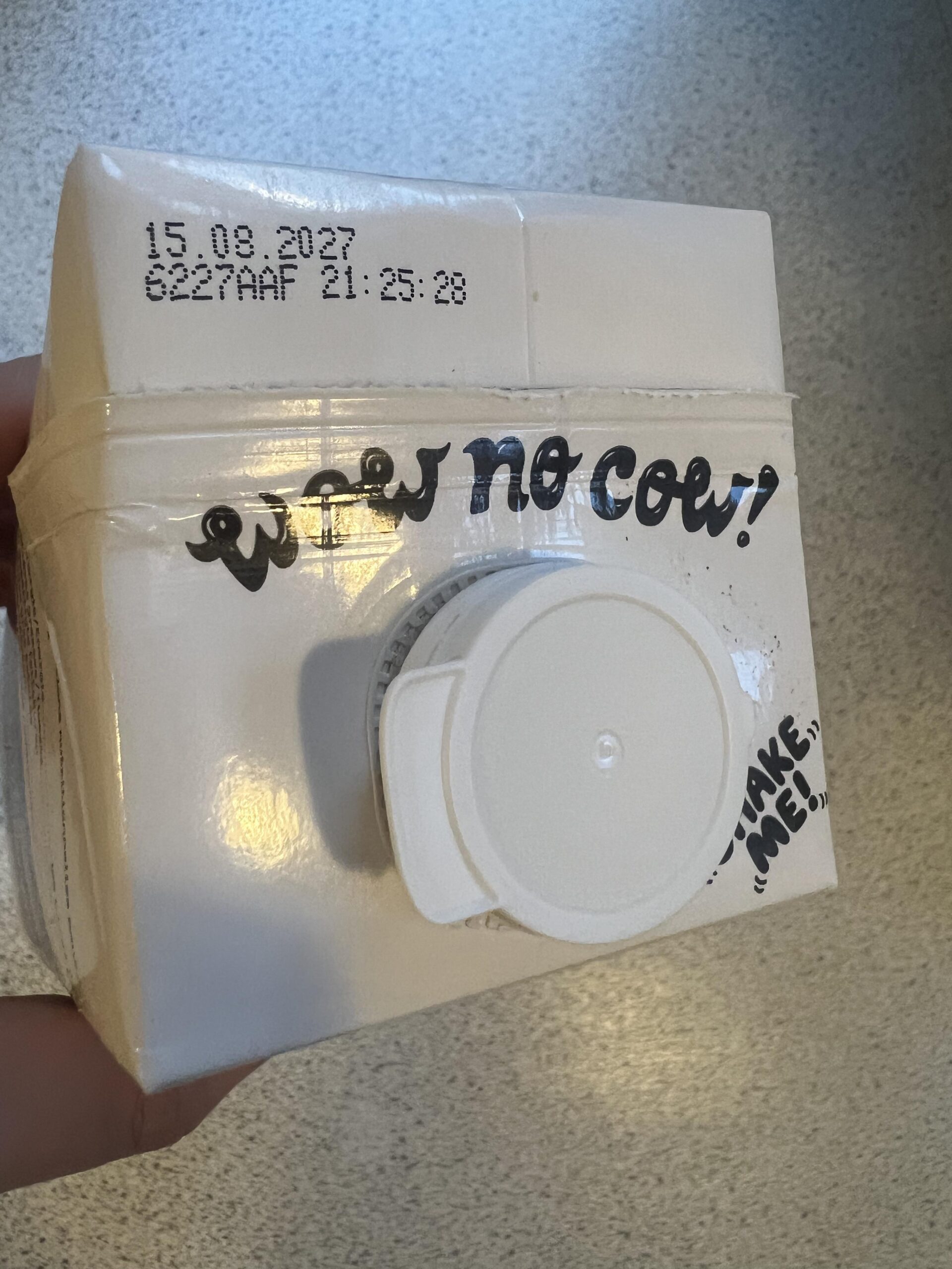 Original photograph of the Oatly No Sugars carton cap and best-before marking
