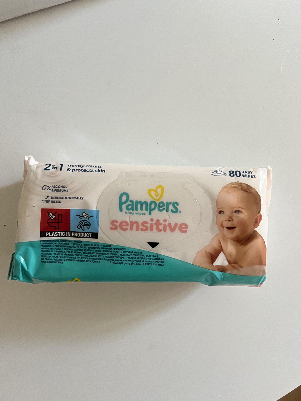 My actual individually wrapped Pampers Sensitive baby wipes 80-count package showing the white teal and pink front with flip-top opening