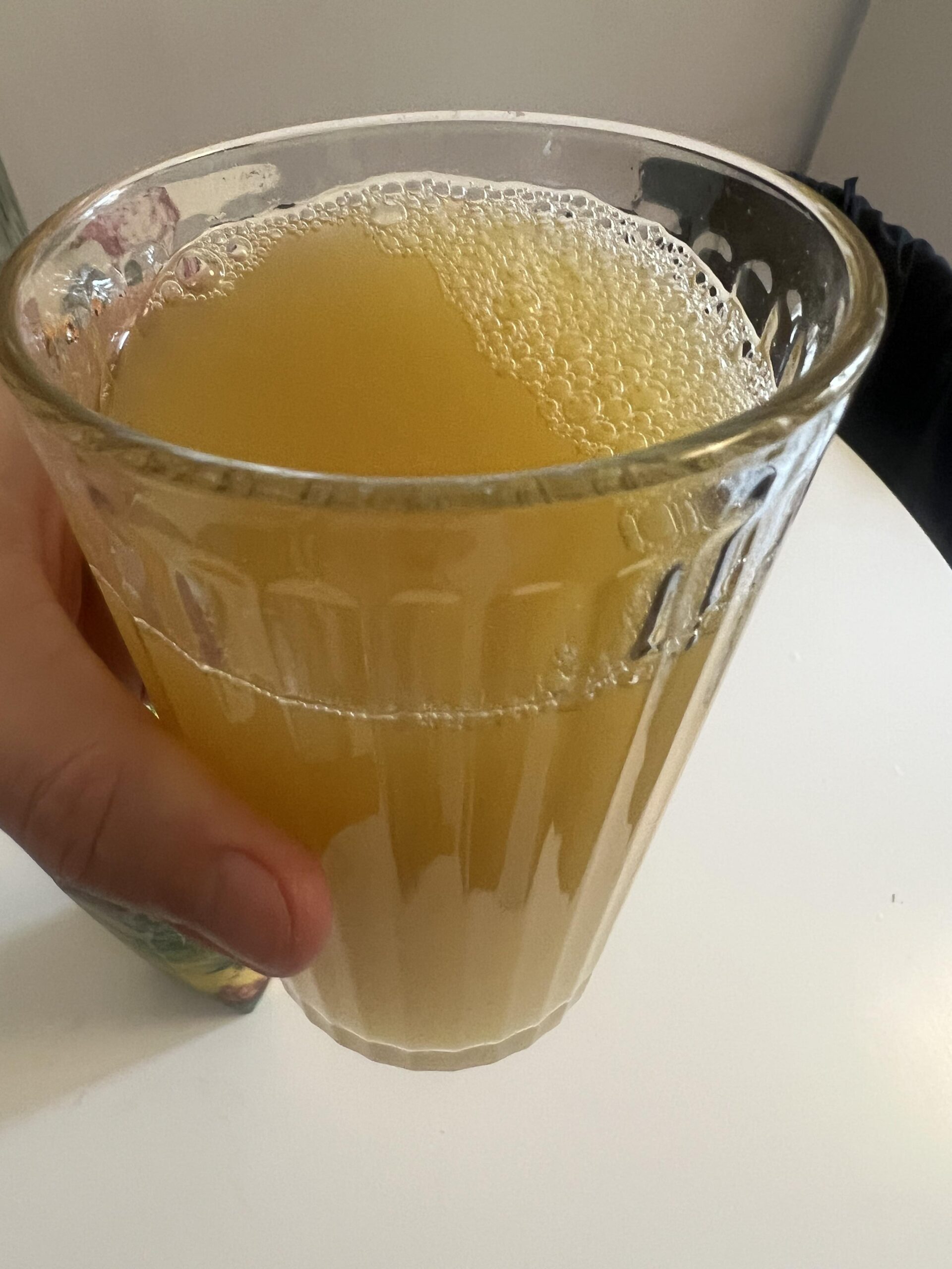 My original close-up photo of golden pineapple juice in a clear glass with small bubbles on the surface