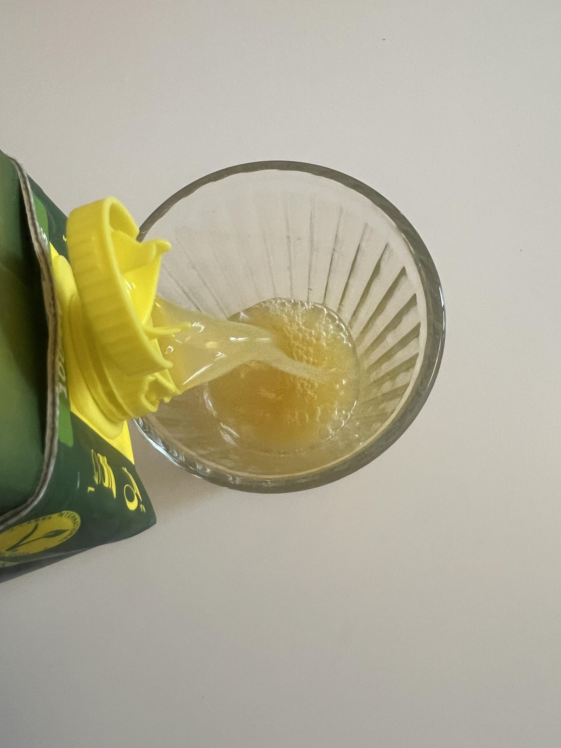 Original overhead photograph showing my Rauch Happy Day pineapple juice being poured into a drinking glass