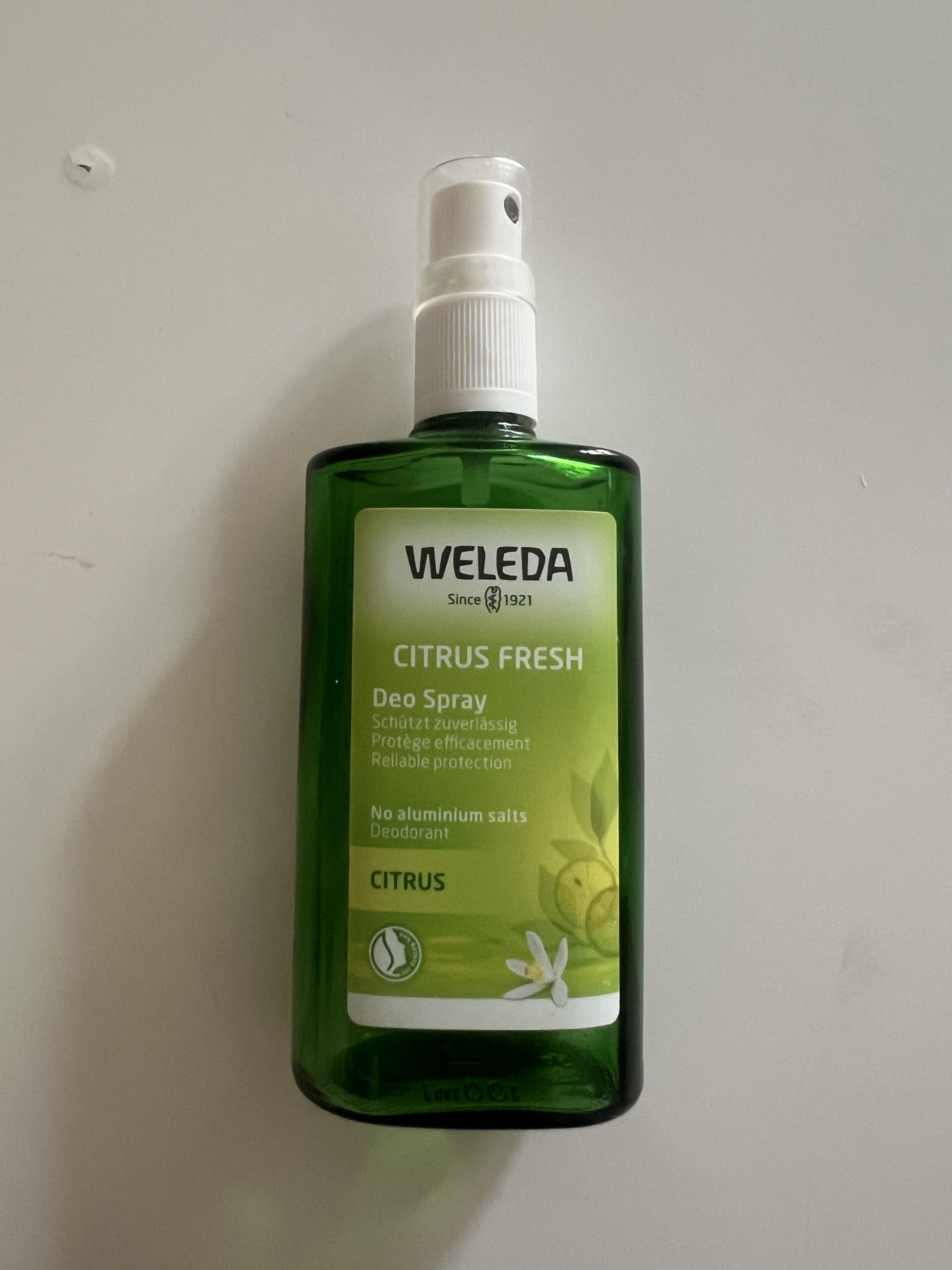 Original upright photograph of Weleda Citrus Fresh Deo Spray 100 ml green glass bottle with white pump and citrus label